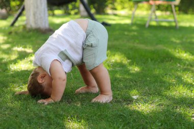 Sevimli Çocuk Açık Havayı Keşfediyor. Neşeli Çocuk Parkta ya da Bahçede güneşli bir günde baş aşağı duruyor..