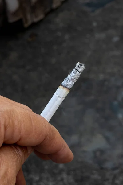 Cigarrillo Ardiente Sostenido Mano Sobre Fondo Oscuro Borroso — Foto de Stock