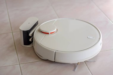 Beyaz robot süpürgesi zemin fayans zemininde.