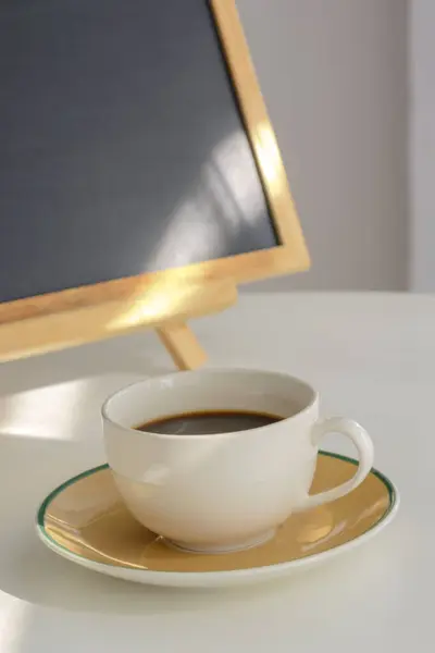 White coffee cup on white table.