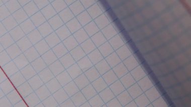 Kağıt parçalarını okul defterindeki kare haline getirmek, yakın plan.