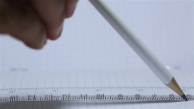 Defterde kalemle bir çizgi çizmek, mühendislik işi, proje cetvelinin altında çizmek, kareli defterde makro çizmek