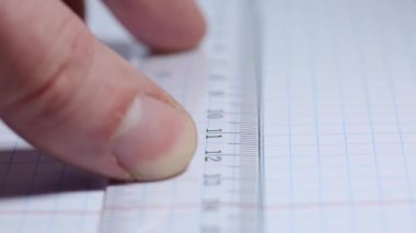 Bir mühendis projesini kurşun kalemle bir cetvelin altına çizer.