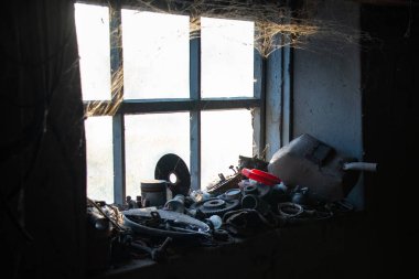 Garaj penceresini örümcek ağları sarmış. Köydeki garaj. Kırsal ortam. Yarasa lambası. Kaynakçının envanteri. Işık parıltısı garaj araçlarını aydınlatır.