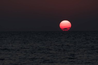 Indian Rocks Beach, Tampa, Florida 'da gün batımında parlayan güneş diski