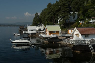 Malmoya yakınlarındaki sahil kulübeleri ve tekneler ve Malmoysundet 'in sakin suları, Norveç, Oslo' daki Malmoysundet Köprüsü 'nden bakıyorlar.