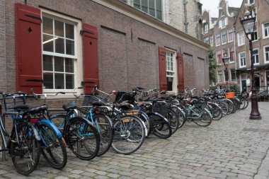 Amsterdam, Oude Kerk 'ün arkasındaki kaldırım taşlı sokakta bisiklet parkında.