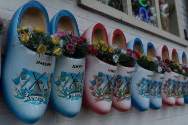 Brightly painted klomps with floral ornaments in workshop in Marken, AMsterdam clipart