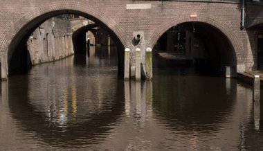 Jacobibrug ve Oudegracht, Utrecht, Hollanda 'nın sakin sularındaki yarı daire tünellerinin yansımaları.