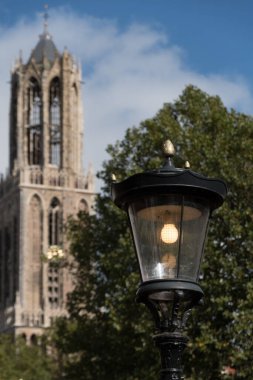 Running street light  with medieval gothic tower  behind it, Utrecht, Netherlands clipart