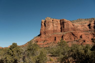Sedona, Arizona yakınlarındaki Oak Creek köyünün kuzeyindeki Kızıl Kaya dağ oluşumlarına yaklaşıyoruz.