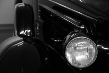 Otuzlu yaşların sonundaki klasik arabanın ön farları, araba fuarında yakın plan.