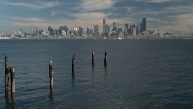 Seacrest Koyu 'ndaki eski bir iskelenin kalıntıları Elliot Körfezi' nin karşısındaki Seattle silueti, Alki Point
