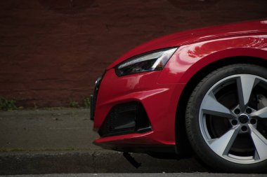 Port Townsend 'de kırmızı tuğlalı duvarın önüne park edilmiş kırmızı bir spor arabanın önünde.