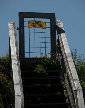 Arka kapıya çıkan ahşap merdiven. Arka planda mavi gökyüzü, Seaview Drive, Port Townsend.