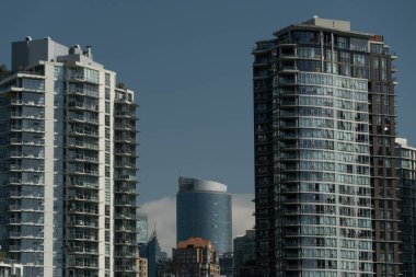 Eşsiz bir şekilde tasarlanmış gökdelenin çarpıcı görüntüsüne bakıyorum. Granville Adası 'ndan daha geleneksel gökdelenlerin arasına doğru eğiliyor.