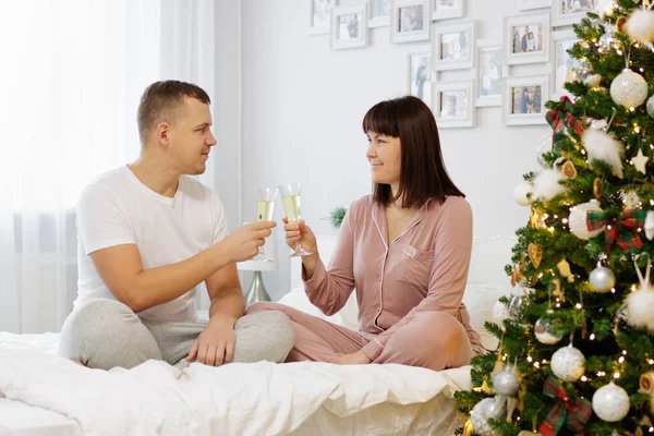 Porträtt Lyckliga Par Sitter Sängen Och Dricker Champagne Dekorerat Sovrum — Stockfoto