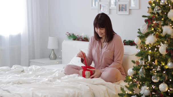圣诞节的概念 快乐的女人在家里打开圣诞礼物 — 图库视频影像