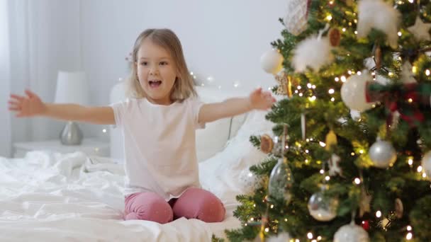 Klein Meisje Ontvangt Kerstcadeau Buurt Van Kerstboom Thuis — Stockvideo