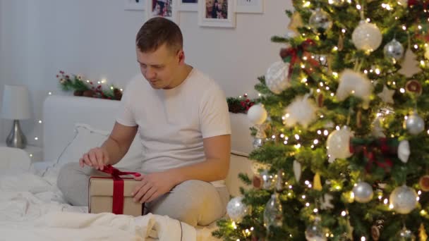圣诞与魔法概念 年轻人在装饰了圣诞树的卧室里打开魔法礼品盒 — 图库视频影像