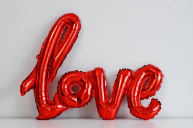 Aşk ve Sevgililer Günü kavramı - kırmızı folyo hava balonu beyaz duvar arkasında aşk mektupları