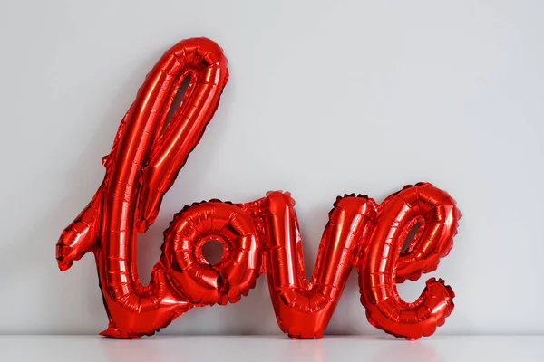 愛とバレンタインデーのコンセプト 白い壁の背景に赤い箔空気気球の愛の手紙 — ストック写真