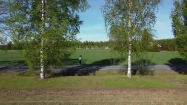 Sağlıklı yaşam tarzı kavramı - Estonya 'da manzaralı kırsal yolda koşan genç bir kadının yan bakışı