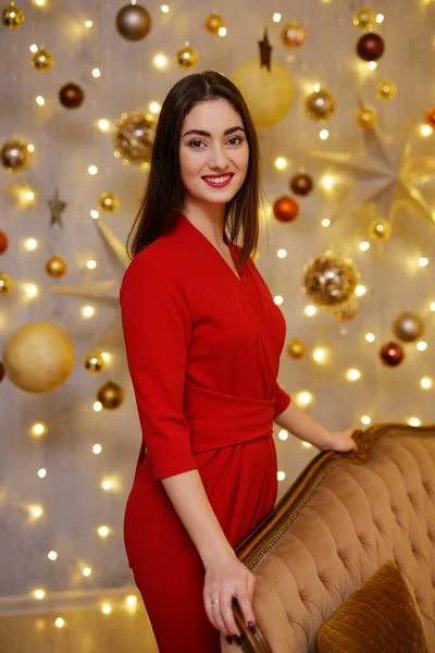 笑顔若いです女性で赤いスーツでクリスマス飾り — ストック写真