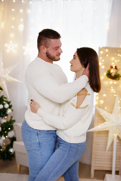 Schönes Junges Paar Umarmt Sich Weihnachtlich Dekoriertem Zimmer — Stockfoto