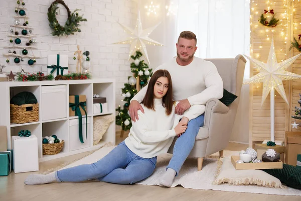 幸せな男と女座ってクリスマス装飾された部屋 — ストック写真