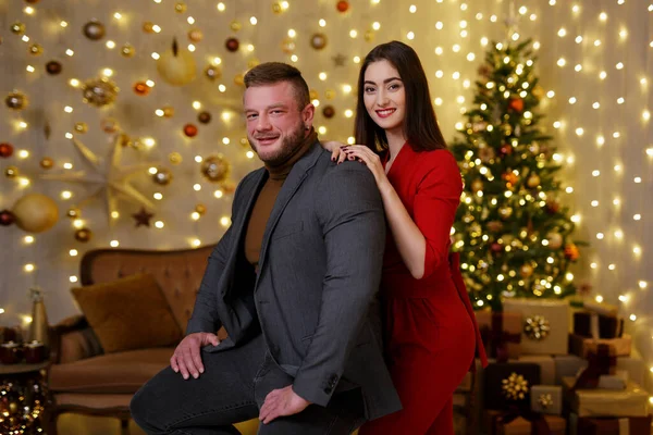 女性抱擁男でクリスマスの装飾された部屋でライト — ストック写真