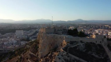 İspanya, Alicante 'de İspanyol bayrağı taşıyan Santa Barbara kalesi - hava manzaralı