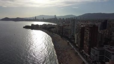beautiful aerial view of sunset over beach promenade, mountains and scyscrapers in Benidorm, Spain