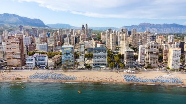 summer vacation, resort and travel concept - beautiful aerial view of beach promenade, mountains and scyscrapers in Benidorm, Spain
