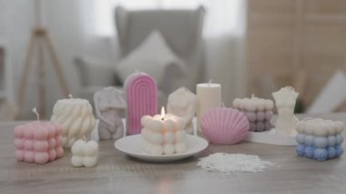 Oturma odasındaki masada renkli el yapımı mumlar.