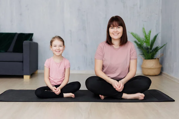 stock image family and sport concept - young mother with little daughter practicing yoga at home