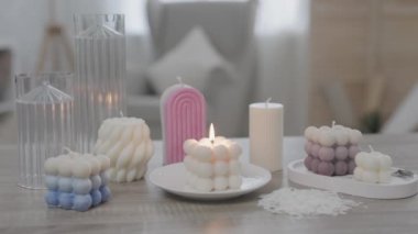 Masanın üzerinde renkli el yapımı mumlar var.