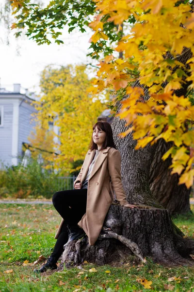 Güz Parkında Oturan Bej Ceketli Güzel Mutlu Kadın — Stok fotoğraf