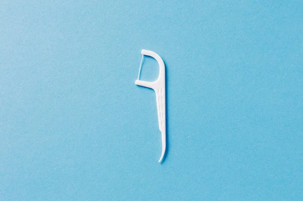 Cepillo Dental Blanco Plástico Con Hilo Dental Sobre Fondo Azul — Foto de Stock