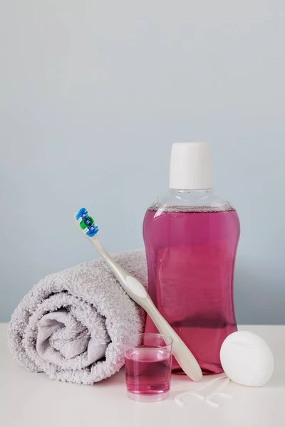 Flaska Med Munvatten Tandborste Handduk Och Tandtråd Bord Med Copyspace — Stockfoto