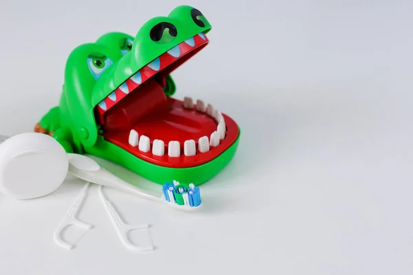 stock image Dental floss, toothpicks, brush and green crocodile on white background