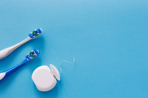 Zahnseide Und Zahnbürsten Von Oben Auf Blauem Hintergrund Mit Kopierraum — Stockfoto