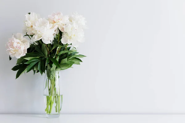 白いテーブルの上に花瓶に美しい新鮮な白い牡丹の花束 — ストック写真