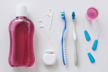 Diş ipi, diş fırçası, kürdan ve beyaz arka planda durulama.