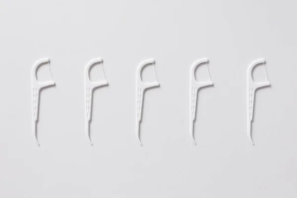 stock image Set of white dental toothpicks with dental floss on white background