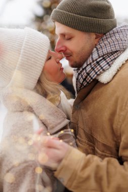 Romantik çift ışıklarla birbirlerine yakın duruyorlar.