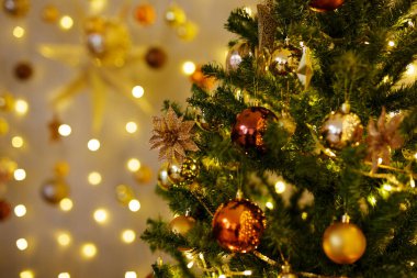 Altın ve kahverengi topları olan güzel noel ağacına yakın.