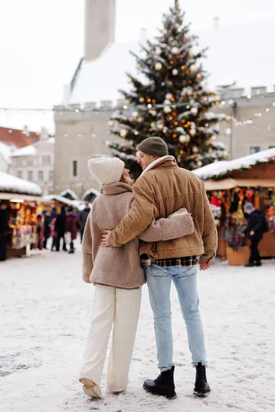 Back view of couple in old town at winter christmas market