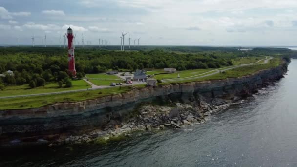 エストニアのパルディスキーの美しい石灰岩の崖の上の古い灯台と風車農場の美しい空中ビュー — ストック動画