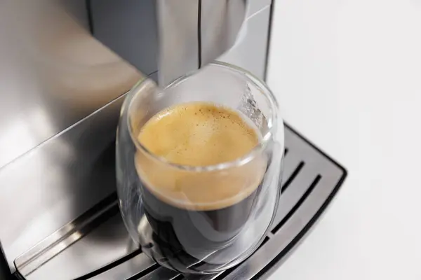 close up of double glass cup of espresso on modern coffee machine